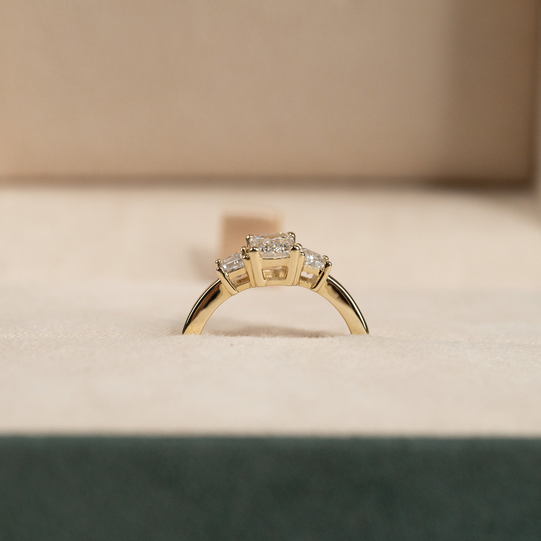 THREE-STONE EMERALD-CUT DIAMOND RING YG